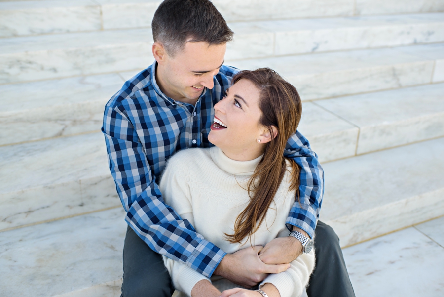 A newly engaged couple cuddle on the steps of the lincoln memorial for their DC engagement session.